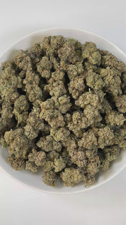 PUFFY Marathon OG is a potent indica-dominant hybrid THCa strain, crafted from the legendary OG Kush lineage, which includes either Chemdawg, Lemon Thai, or Hindu Kush. The aroma is bold and layered, combining gassy sharpness with earthy depth and a touch of warm spice. Visually, the buds are dense and deep forest green, accented by darker undertones, vivid bright orange pistils, and a thick coating of frosty white trichomes, signaling its high potency. Consumers often report a balance of euphoria and relax