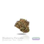 PUFFY Blueberry Pancake is an indica-dominant hybrid born from the cross of DJ Short Blueberry and either Purple Panty Dropper or a hybrid with Slurricane. The aroma carries a burst of ripe blueberries layered with sour notes and a delicate floral finish. Visually, the buds are dense and heavily coated in trichomes, displaying a vibrant mix of deep green, blue-purple, and olive tones, accented by bright orange pistils and a thick layer of visible resin. Consumers often report a soothing cerebral uplift that