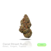 PUFFY Canal Street Runtz is a balanced hybrid THCa strain, expertly crafted from the cross of Pre-64 Runtz and THC Bomb. The aroma blends sharp diesel and pungent fuel notes with a sweet tropical twist, creating a bold yet exotic profile. Visually, the buds show deep green and purple hues, fiery orange pistils, and a glittering trichome. Consumers often report a euphoric, energizing high that boosts creativity and focus while also promoting relaxation and stress relief.
