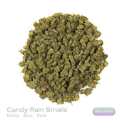 PUFFY Candy Rain (smalls) is an indica-dominant hybrid THCa strain, crafted from the flavorful cross of London Pound Cake × Gelato. The aroma is a bold and playful blend of sweet candy, tangy sour notes, and rich, dank undertones, creating a vibrant and memorable scent profile. Visually, dense green buds with purple hues and fiery orange pistils are coated in sticky trichomes. Consumers often report experiencing a happy and euphoric mood, accompanied by relaxed, calm body sensations and uplifted, giggly fee