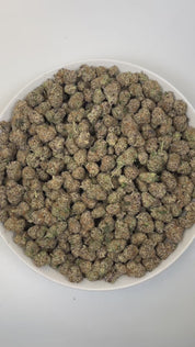 PUFFY Lunch Money is a balanced hybrid THCa strain, created from the fusion of Money Gun and Grape Pie BX. The aroma is funky, with sharp notes of cheese and a hint of savory onions. Visually, dense deep green buds with purple hues and fiery orange pistils are coated in sticky trichomes. Consumers often report an uplifted mood and euphoria, accompanied by a balanced cerebral buzz, relaxed body sensation, and mellow focus.