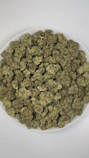 PUFFY Peach Ringz is an indica-dominant hybrid THCa strain born from the flavorful cross of Marionberry and Eddy OG. The aroma bursts with gassy, sweet, and fruity notes, creating an enticing and vibrant sensory experience. Visually, the buds are bushy and densely packed, covered in glistening trichomes with minty  green tones and dark olive undertones. Consumers frequently describe this strain as offering a harmonious experience, starting with a light, uplifting mental clarity that brightens the mood, foll