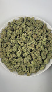 PUFFY Lemon Candy is a sativa-dominant hybrid THCa strain, crafted from the legendary lineage of American indica with NYC Diesel. The aroma is a vibrant blend of zesty lemon with grounding earthy undertones, creating a refreshing and invigorating scent. Visually striking, these dense, frosty buds glisten with trichomes, displaying deep greens with hints of lime and purple, accented by vibrant orange pistils. Consumers often report an initial wave of uplifting euphoria that elevates the spirit and energizes 