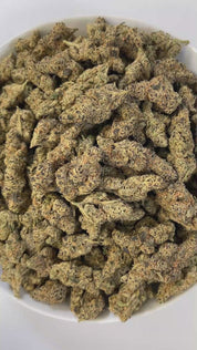 PUFFY Gelonade is a sativa-dominant hybrid THCa strain created by crossing Lemon Tree with Gelato #41. The aroma is a bold blend of sharp gas, fresh herbal notes, and a hint of rich cedar, creating a complex and invigorating scent profile. Visually, the buds have a dense, grape-like structure, showcasing lime-green tones with purple hues and orange pistils, all coated in glistening trichomes. Consumers often report a bright, uplifting experience with a clear-headed cerebral buzz that boosts creativity, focu