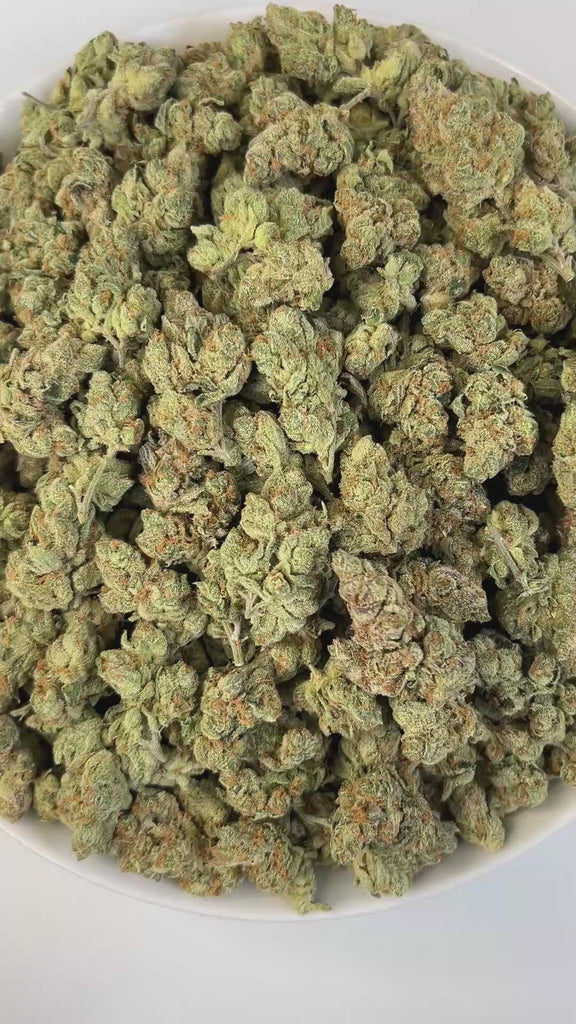 PUFFY Strawberry Banana is an  indica-dominant THCa strain result of crossing Crockett’s Banana Kush with the Strawberry phenotype of Bubble Gum. Aroma bursts with a harmonious blend of fruity and juicy notes, enriched by subtle earthy undertones, layered with a sweet, creamy finish. Visually buds dazzle with vibrant green and deep purple hues, bright orange hairs, and a frosty coat of amber trichomes that sparkle with potency. Consumers report that it delivers a blissfully happy and peaceful high, known fo