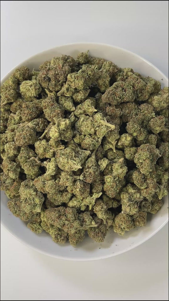 PUFFY Apple Smackz is a sativa-dominant THCa strain, expertly crafted from a flavorful cross between Apple Jack and Grape Pie. The aroma is earthy, musky, and woody, with a rich, natural scent that evokes the feeling of walking through a dense forest surrounded by damp soil and aged wood. Visually, the buds are vibrant lime green with a compact, tapered structure, featuring vivid orange pistils and a frosty layer of white-blue trichomes. Consumers often describe feeling uplifted and clear-headed, with a cal