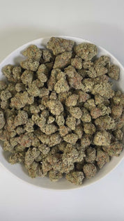 PUFFY Canal Street Runtz is a balanced hybrid THCa strain, expertly crafted from the cross of Pre-64 Runtz and THC Bomb. The aroma blends sharp diesel and pungent fuel notes with a sweet tropical twist, creating a bold yet exotic profile. Visually, the buds show deep green and purple hues, fiery orange pistils, and a glittering trichome. Consumers often report a euphoric, energizing high that boosts creativity and focus while also promoting relaxation and stress relief.

