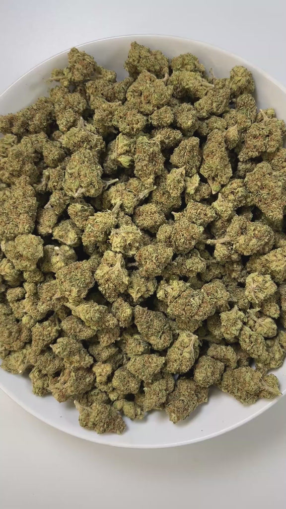 PUFFY Shake Shack is a balanced hybrid THCa strain, born from the flavorful cross of Ice Cream Cake × OG Fruit Smoothie. The aroma combines sharp diesel notes with a cool, minty freshness and a strong gassy undertone. Visually, the buds are dense and chunky, showing forest-green tones with frosty trichomes and subtle orange-amber pistils for contrast. Consumers often describe a soothing full-body relaxation paired with a calm, clear mind, while others note uplifting effects that boost mood, spark euphoria, 