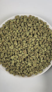 PUFFY Garlic Banana (smalls) is an Indica-dominant hybrid THCa strain born from the flavorful cross of Garlic Cookies × Black Bananas. The aroma comes through with a bold blend of sweet banana layered over sharp garlic notes, rounded out by a deep, musky undertone. Visually, the resinous buds feature forest-green and purple tones, bright orange pistils, and a frosty trichome coating. Consumers often report a burst of uplifting, euphoric creativity that gradually melts into a soothing full-body calm, gently 