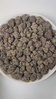 PUFFY Laffy Taffy is a sativa-dominant hybrid THCa strain, born from the flavorful cross of Banana OG and Pestilence. The aroma is a delightful blend of sweet candy, juicy berries, and subtle earthy undertones. Visually, the buds are dense and striking, showcasing deep green and rich purple hues, accented by bright orange pistils and a sparkling layer of trichomes. Consumers often report an uplifting and euphoric high that brings happiness, energy, and mental clarity, fostering creativity and focus, while g