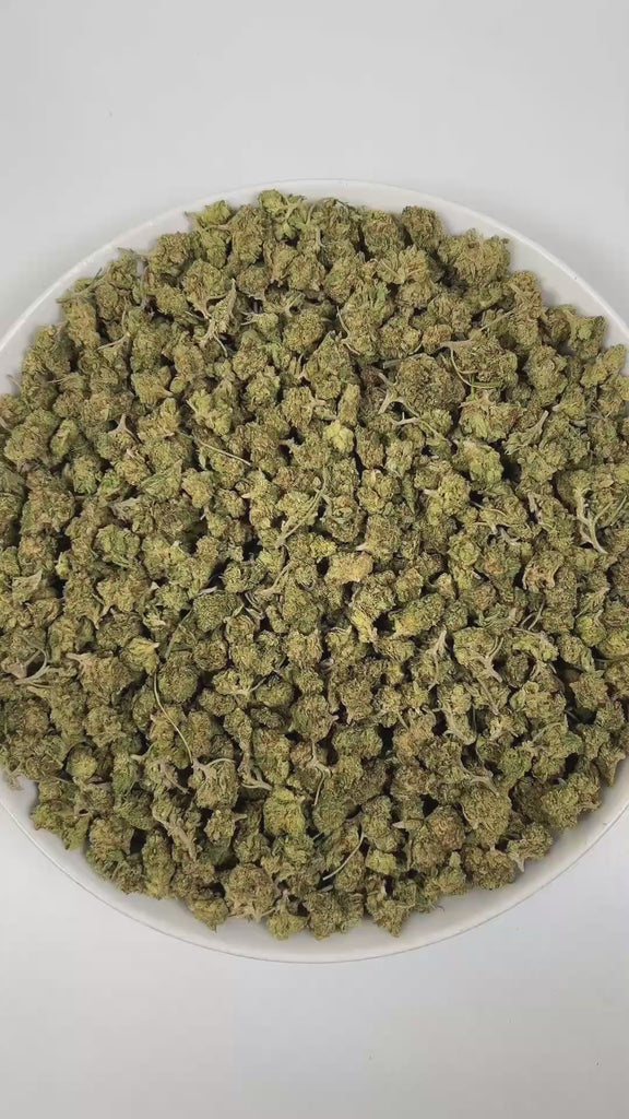 PUFFY Almond Mochi (smalls) is a balanced hybrid THCa strain, crafted from the flavorful cross of Mochi and Biscotti Dough. The aroma is a bold and intriguing blend of diesel, nutty undertones, and a subtle hint of vanilla, creating a rich and inviting scent profile. Visually, dense deep green buds with hints of purple are threaded with fiery orange pistils and coated in a sparkling layer of sticky trichomes. Consumers often report a balanced high combining happy, creative, and euphoric effects with calming