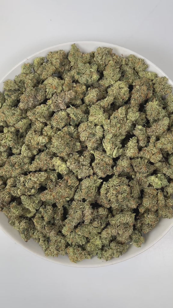 PUFFY UK Cheese is an indica-dominant hybrid THCa strain, renowned for its roots it showcases either a classic Skunk #1 expression or subtle hints of its iconic heritage. The aroma is a captivating blend of gassy, pine, and floral notes, creating a bold yet refreshing sensory experience. Visually, dense green buds with purple hues and fiery orange pistils are coated in sticky trichomes. Consumers often report euphoric, happy, and uplifted sensations paired with a relaxed, energetic feel that engages both th
