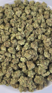 PUFFY Garlic Banana (smalls) is an Indica-dominant hybrid THCa strain born from the flavorful cross of Garlic Cookies × Black Bananas. The aroma opens with rich earthy notes, balanced by a sweet and fruity essence, rounded out with a smooth, creamy finish. Visually, the resinous buds feature forest-green and purple tones, bright orange pistils, and a frosty trichome coating.  Consumers often report a burst of uplifting, euphoric creativity that gradually melts into a soothing full-body calm, gently unwindin