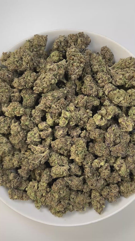PUFFY Pink Certz is a balanced hybrid THCa strain, created from the potent pairing of The Menthol and Grape Gasoline. The aroma combines sweet, candy-like notes with hints of juicy grape, layered over a sharp, earthy diesel scent. Visually, dense frosty buds glow neon green with golden hints and pink-orange hairs, coated in sparkling, gem-like trichomes. Consumers often experience an uplifting, clear-headed euphoria that sparks creativity and focus, followed by gentle body relaxation, making it ideal for mo