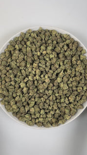 PUFFY Ice Cream Cake (smalls) is an Indica-dominant hybrid THCa strain, born from the potent cross between Wedding Cake and Gelato #33. The aroma unfolds with warm baked notes, sweet hints of vanilla, and delicate floral undertones. Visually, its buds are dense and chunky, showcasing a vibrant mix of green and purple hues with occasional touches of lavender, accented by fiery orange pistils. Consumers often report an experience that begins with a euphoric, uplifting cerebral high, gradually easing into a de