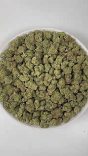 PUFFY Bubba Kush is an indica-dominant hybrid THCa strain, crafted from the legendary lineage of OG Kush × Afghani Indica. The aroma is a lively blend of sweet oranges and ripe berries, underlined by a distinct gassy note, creating a bright, tangy, and slightly pungent scent profile. Visually striking, the buds are dense and resin-packed, shimmering with frosty trichomes over deep green and purple hues accented by bright orange hairs. Consumers often describe the effects as a wave of full-body relaxation th