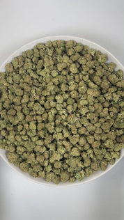 PUFFY Truffle Butter (smalls) is an Indica-dominant hybrid THCa strain, born from the flavorful cross of Gelato and Chocolate Kush. The aroma unfolds in a vibrant mix of fruity notes balanced by deep coffee richness and a gentle nutty twist. Visually, the buds are dense and striking, showcasing a deep forest-green base with vibrant purple hues, bright orange pistils, and a sparkling coating of trichomes. Consumers often report an initial burst of euphoria and uplifted mood, gradually giving way to deep phys