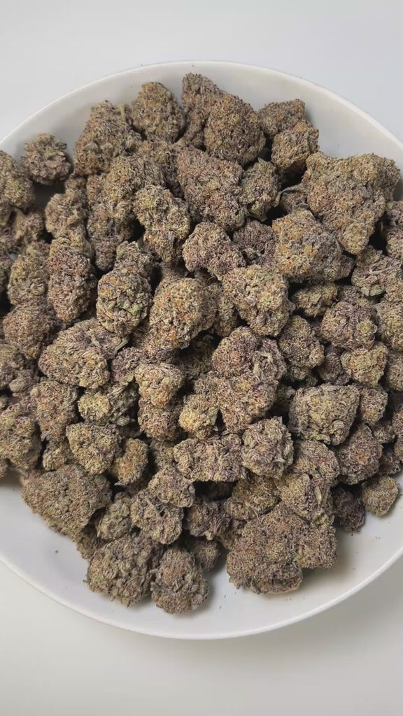 PUFFY Blackberry Diesel is a sativa-dominant hybrid THCa strain, expertly crafted from the cross of East Coast Sour Diesel and Plushberry. The aroma presents a complex blend of sweet berries, delicate floral notes, and a hint of gasoline, creating a uniquely vibrant and intriguing scent profile. Visually, compact buds burst with neon green, lavender, and deep purple, streaked with orange pistils and frosted in sparkling trichomes. Consumers frequently describe a wave of euphoria accompanied by heightened en