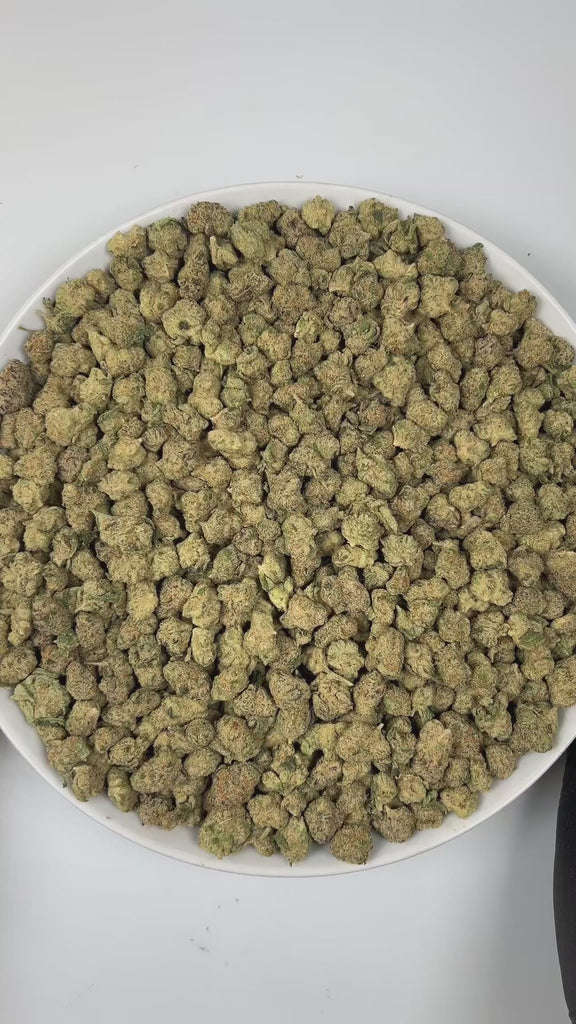 PUFFY Carbon Fiber (smalls) is a balanced hybrid THCa strain, created from a potent blend of Grape Pie, Biscotti, and Cookies & Cream. The aroma unfolds with a rich earthy base, complemented by smooth, creamy notes and a subtle, spicy hint of pepper. Visually, the buds are dense and striking, featuring deep green and purple hues, coated in frosty trichomes and accented with bright orange pistils. Consumers often describe the smoke as creamy and smooth, with a powerful high that feels giggly, tingly, and men