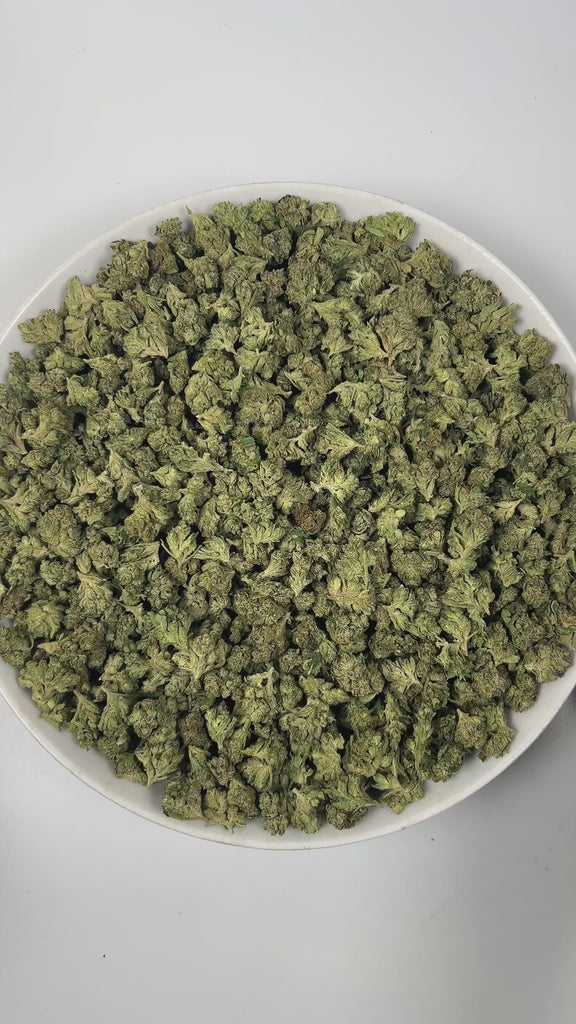 PUFFY Peach Pie (smalls) is an indica-dominant hybrid THCa strain, expertly crafted from a potent cross between Rainbow Pie and Dozizoz. The aroma opens with sweet, juicy notes of ripe peach, smoothly layered with warm vanilla undertones and grounded by a subtle, earthy finish. Visually, the dense buds display deep green and purple hues, bright orange pistils, and a sparkling layer of trichomes. Consumers often report a balanced experience, beginning with uplifting euphoria and mood enhancement, followed by