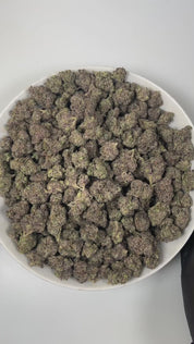 PUFFY Gobbstopper is a balanced hybrid THCa strain, meticulously crafted through the expert crossbreeding of Purple Urkle and Sin City Kush. The aroma bursts with a vibrant blend of grape and berry notes, complemented by earthy undertones and a zesty, invigorating finish. Visually, the buds are dense, with deep green and purple hues, bright orange pistils, and a sparkling coating of trichomes. Consumers often report a balanced experience of relaxation, euphoria, and uplifted mood, creating a pleasant and en