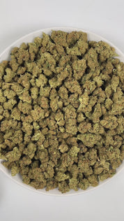 PUFFY GMO, also known as Garlic Cookies, is an indica-dominant hybrid THCa strain crafted from the legendary lineage of Girl Scout Cookies and Chemdawg. The aroma is a bold blend of gassy, pungent onion notes layered with earthy herbal undertones, creating a sharp and savory scent profile. Visually, buds are dense and frosty, featuring spring green and purple hues with bright orange pistils and a thick coating of sparkling trichomes. Consumers often report euphoric and uplifting mental effects that elevate 